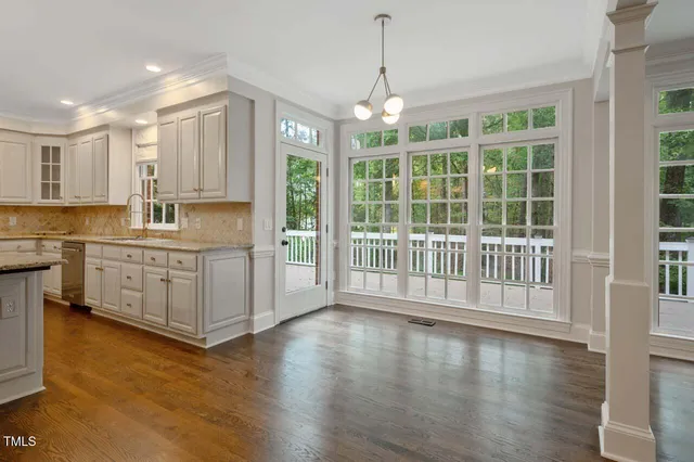 a kitchen with stainless steel appliances granite countertop a stove a sink and a large window