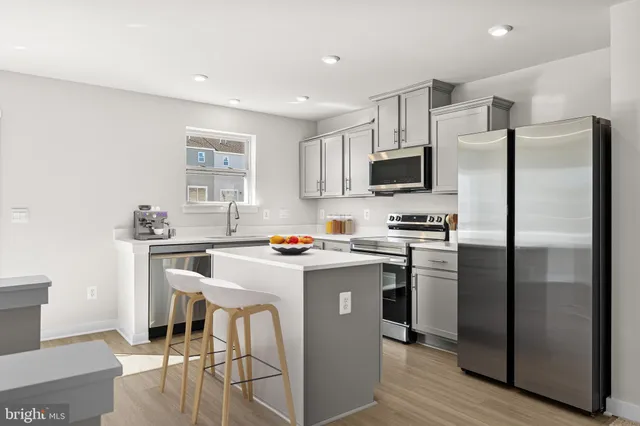 a kitchen with stainless steel appliances a refrigerator stove microwave and sink