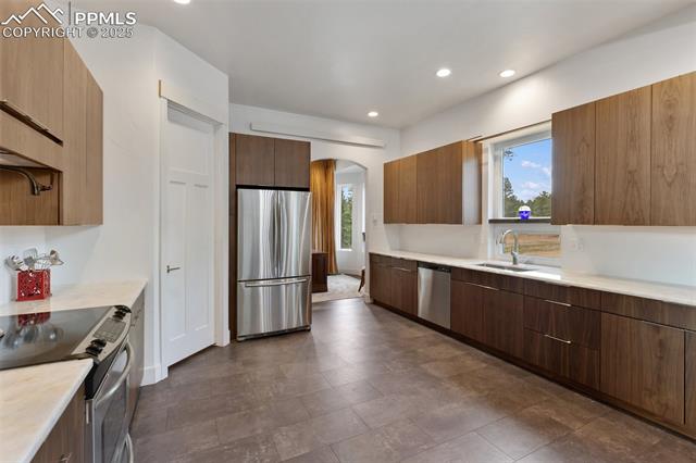 983 Rangeview Road Divide, CO 80814 - Photo 19 of 50 Kitchen with authentic black walnut cabinets and gorgeous quartz counter tops