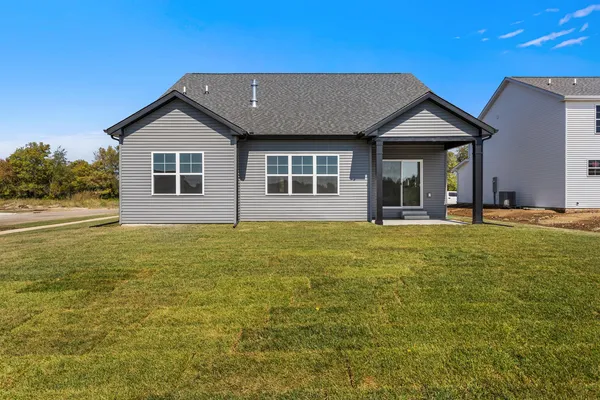 a house with huge green field in front of it