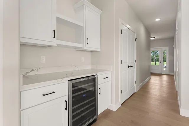 a kitchen with white cabinets and chairs