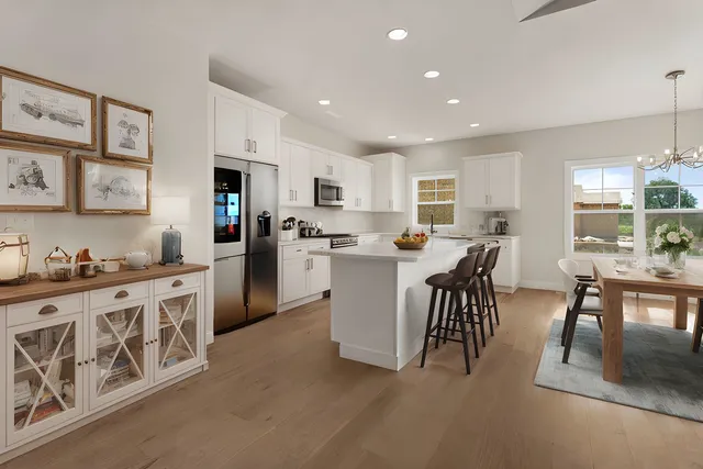 a kitchen with stainless steel appliances granite countertop a refrigerator a sink dishwasher a stove and white cabinets with wooden floor