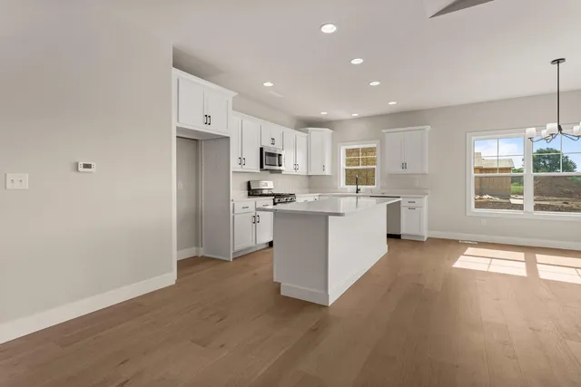a kitchen with granite countertop a sink stove and refrigerator
