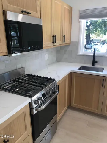 a kitchen with stainless steel appliances granite countertop a sink stove and refrigerator