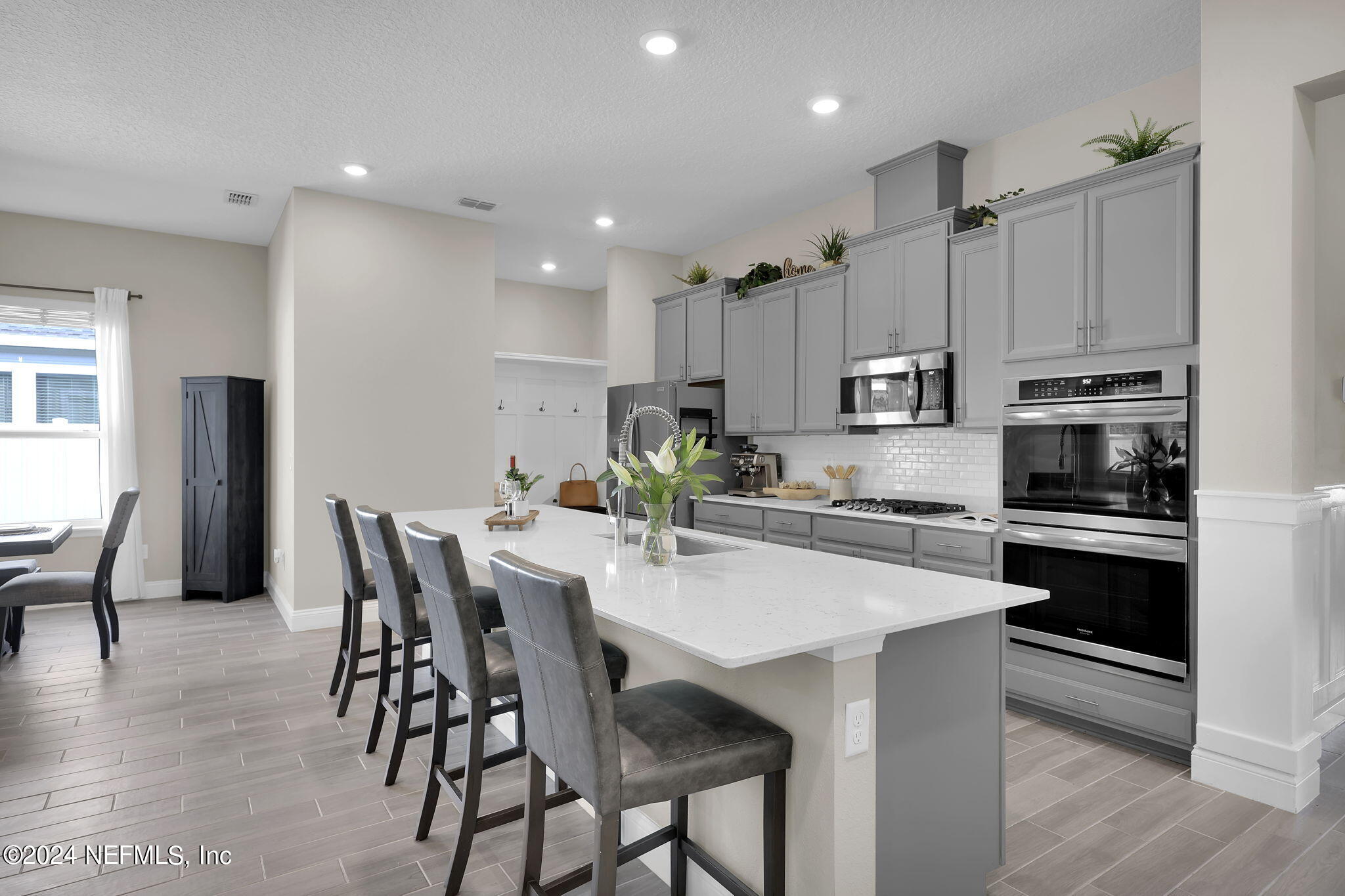 100 Calliel Way St. Johns, FL 32259 - Photo 7 of 50 a kitchen with stainless steel appliances kitchen island granite countertop a table chairs and a refrigerator