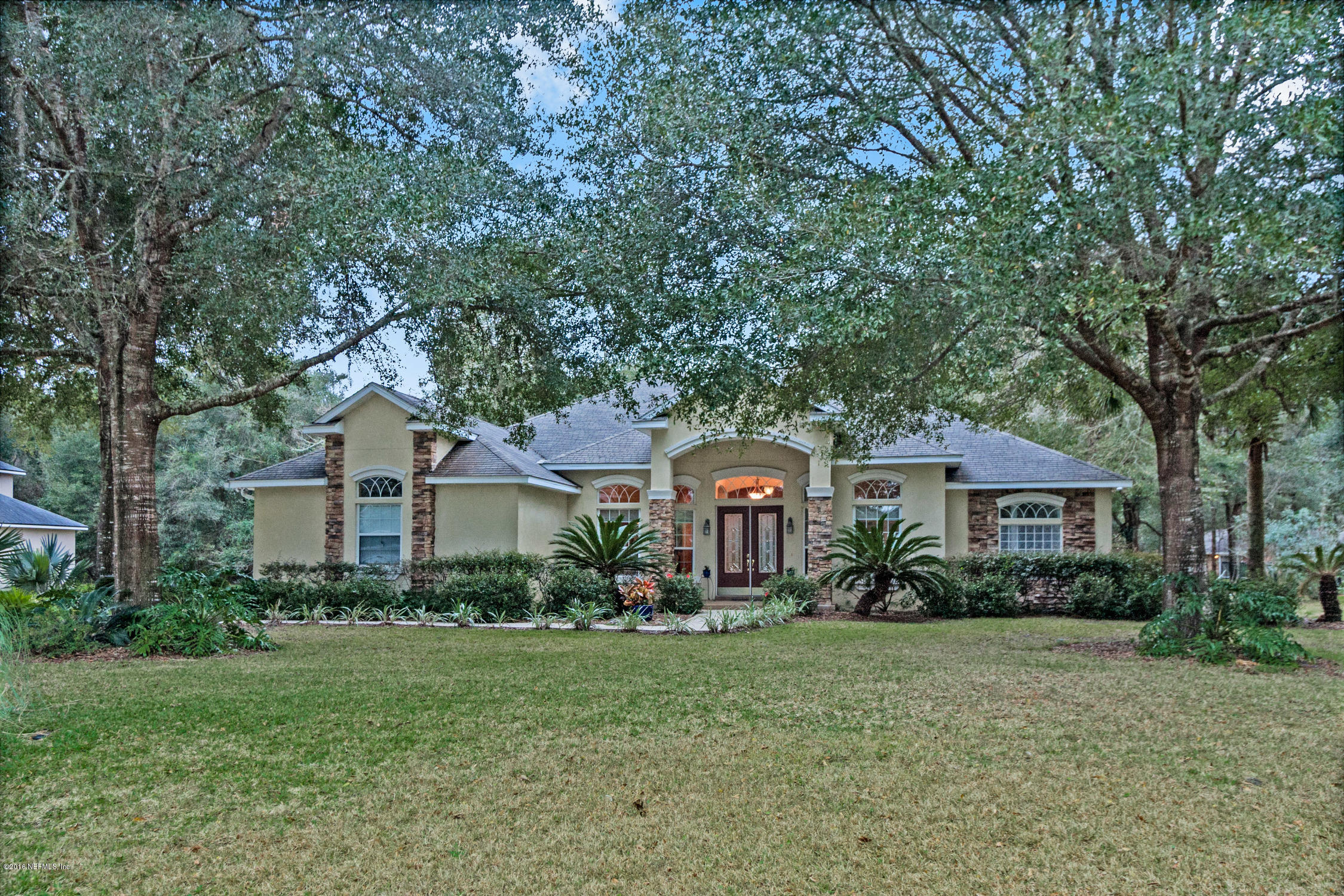 3357 Kings Road South St. Augustine, FL 32086 - Photo 1 of 31 a front view of a house with a garden and trees