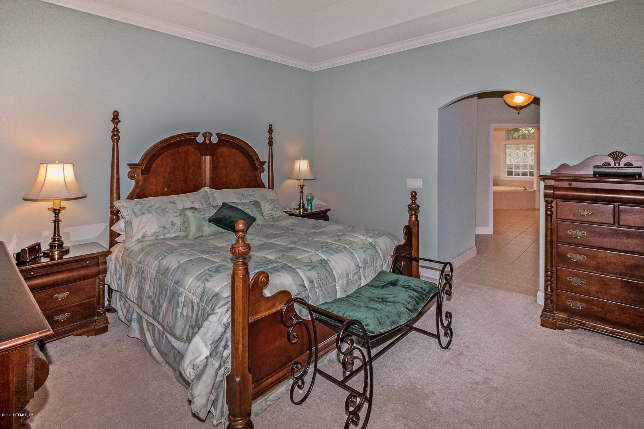 3357 Kings Road South St. Augustine, FL 32086 - Photo 15 of 31 a bedroom with a bed and a chandelier