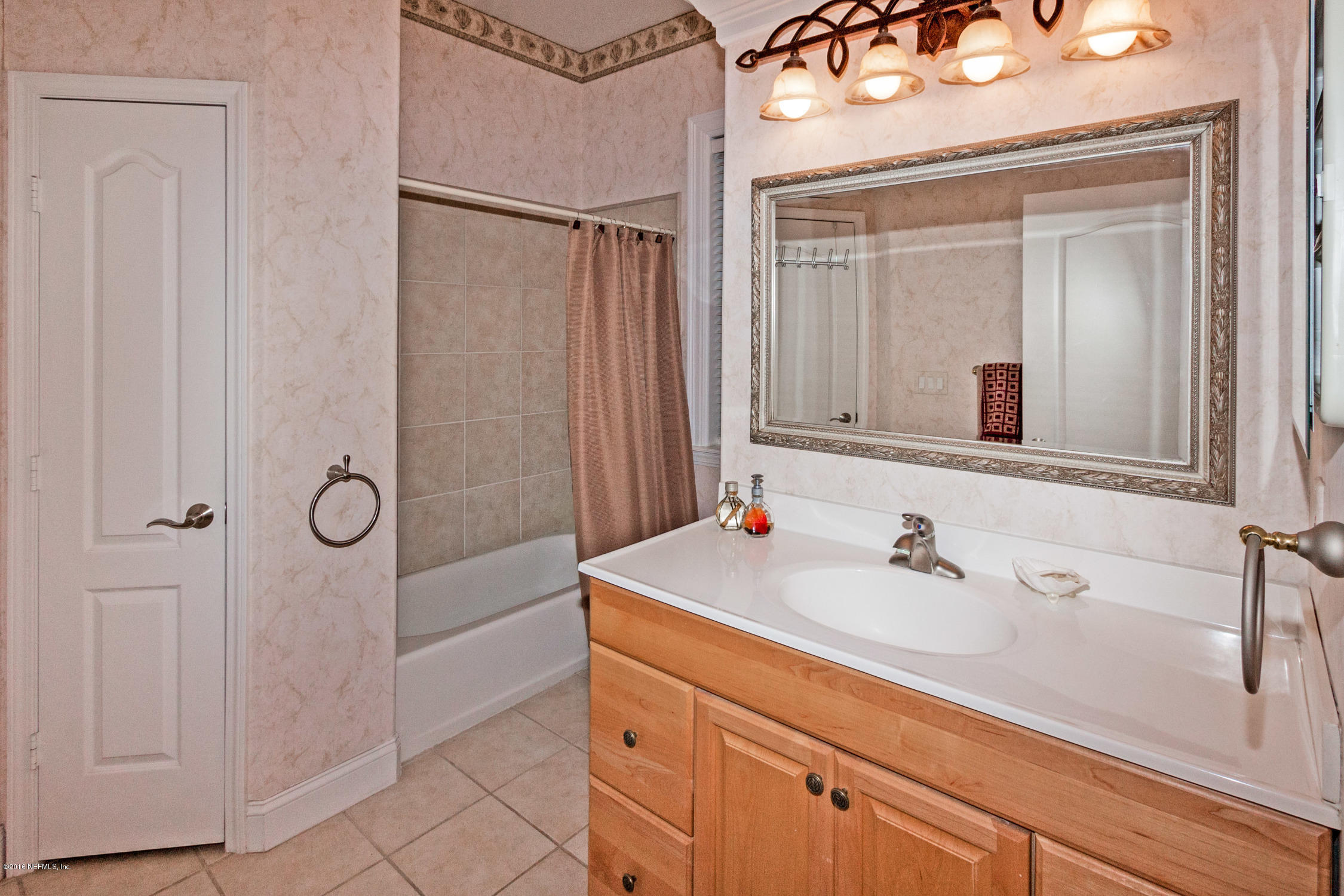 3357 Kings Road South St. Augustine, FL 32086 - Photo 20 of 31 a bathroom with a sink a vanity a mirror and a shower