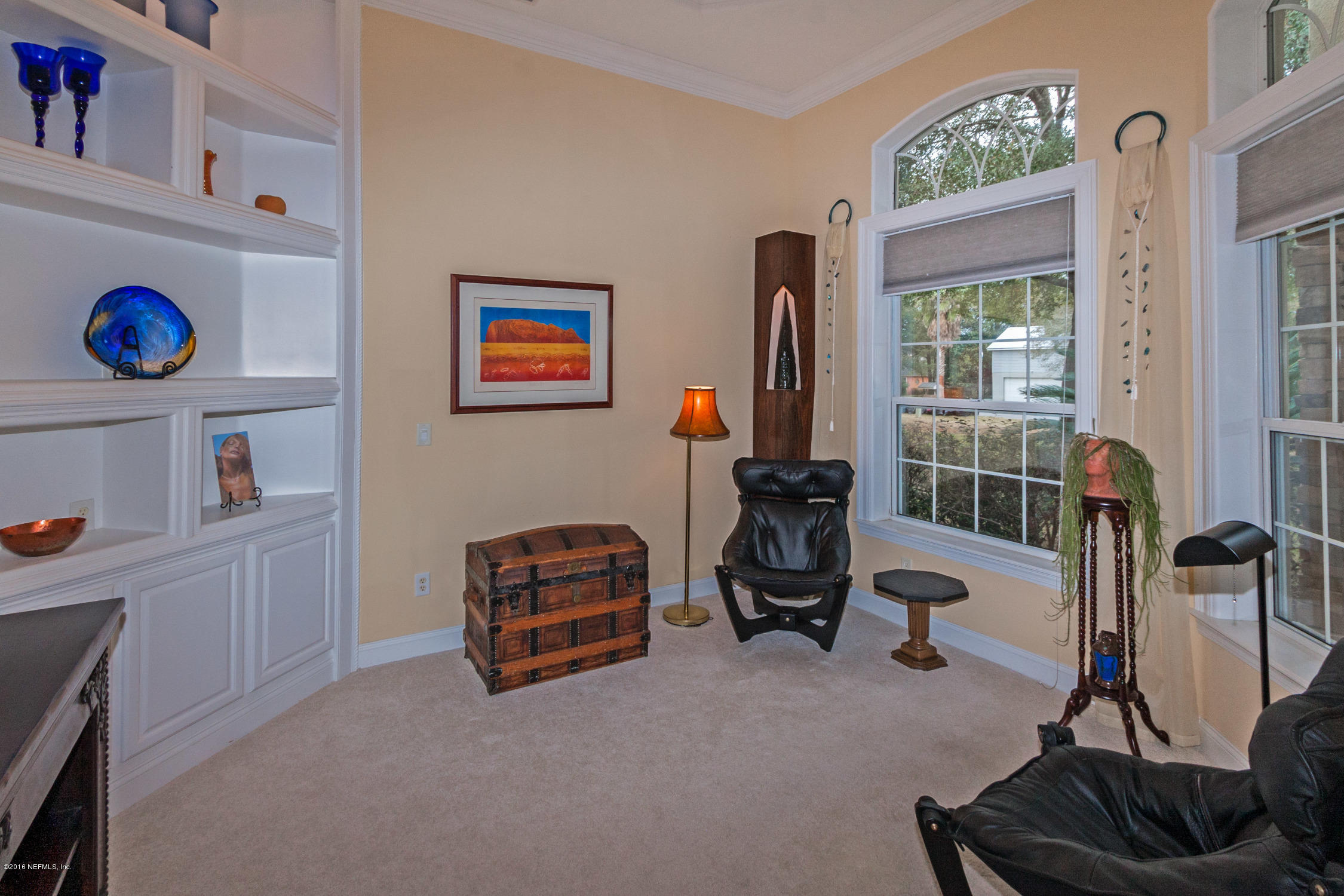 3357 Kings Road South St. Augustine, FL 32086 - Photo 22 of 31 a living room with furniture and a gym machine next to a window