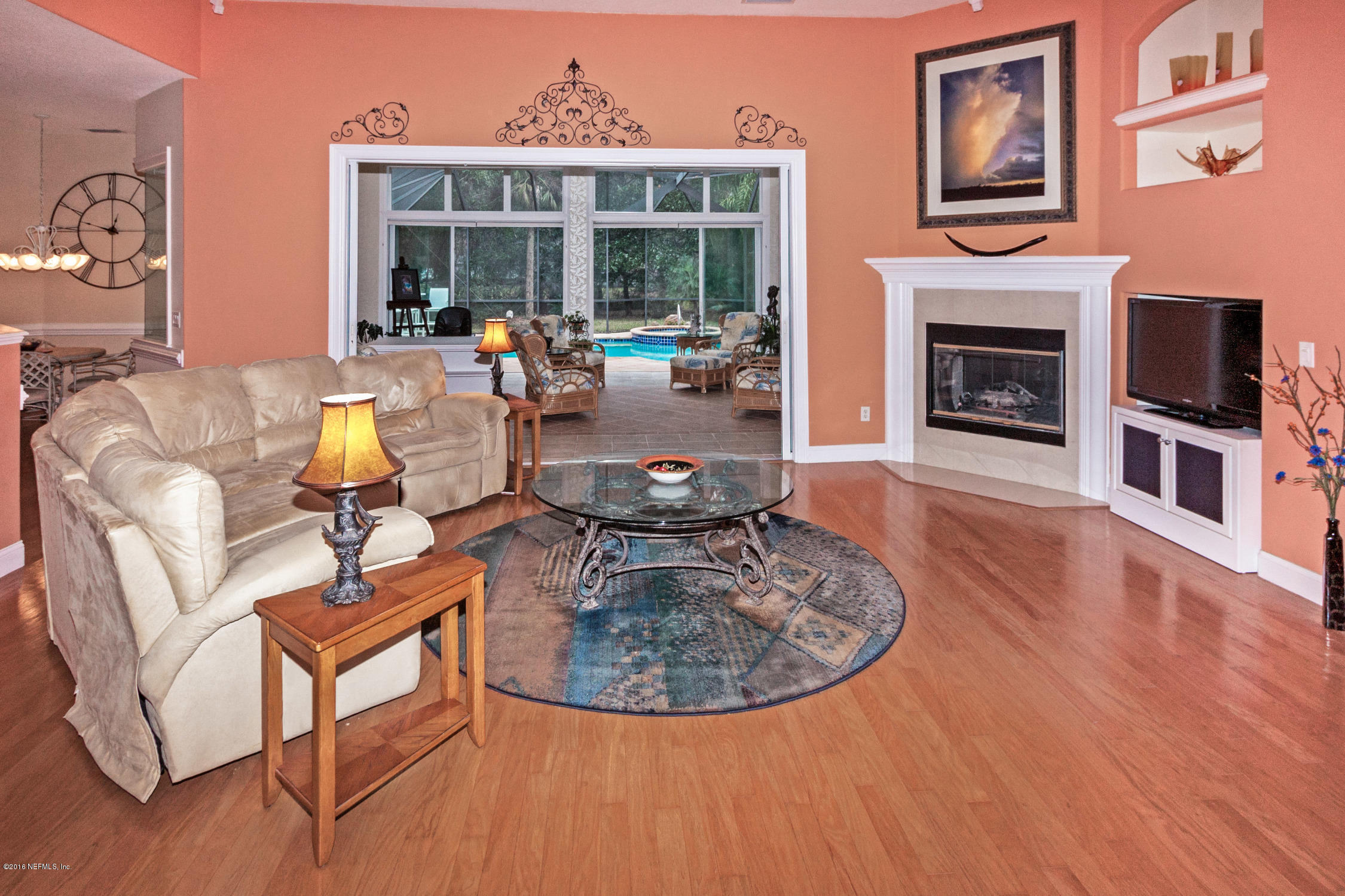 3357 Kings Road South St. Augustine, FL 32086 - Photo 8 of 31 a living room with furniture a fireplace and a large window