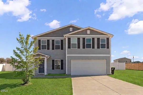 a front view of a house with a garden and yard