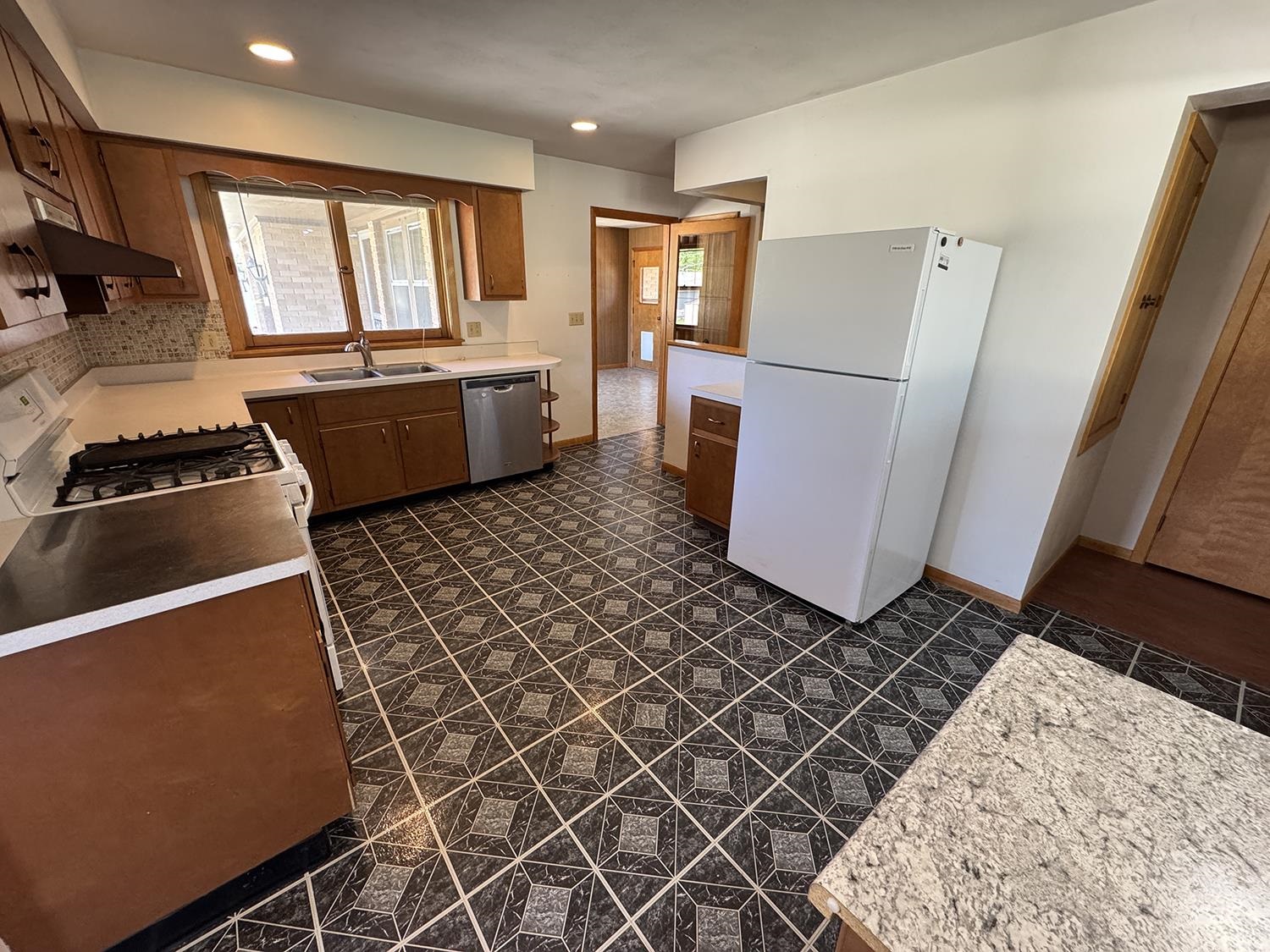 401 South Ridge Street Shannon, IL 61078 - Photo 16 of 40 a kitchen with a sink a refrigerator freezer a stove and a window