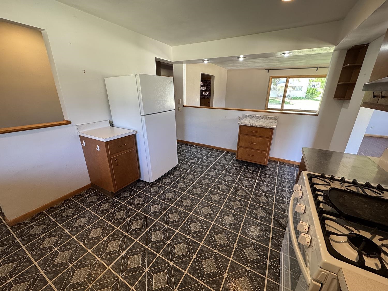 401 South Ridge Street Shannon, IL 61078 - Photo 18 of 40 a kitchen with granite countertop a stove a refrigerator and wooden cabinets