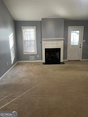 a view of an empty room with window and fire place