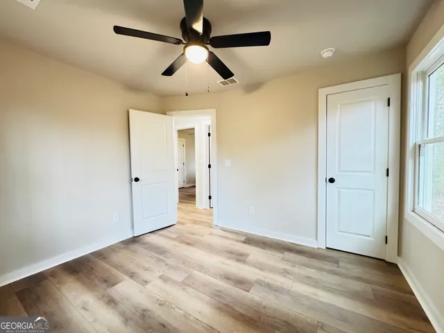 a view of empty room with wooden floor