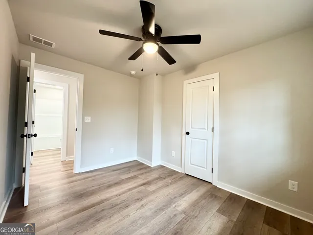 a view of empty room with wooden floor