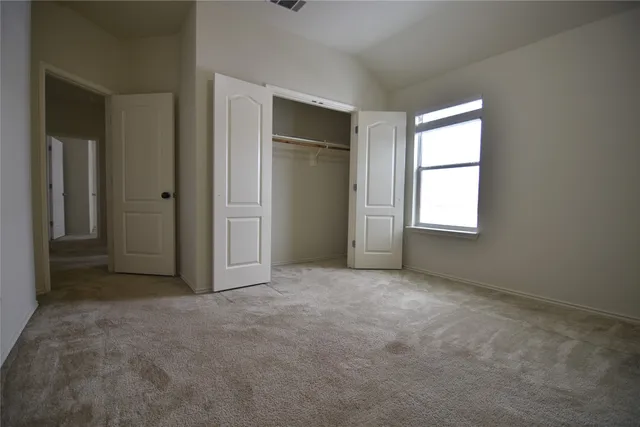 an empty room with windows and closet