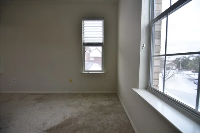 an empty room with windows and closet