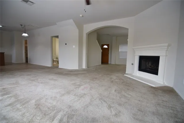 an empty room with fireplace and fan