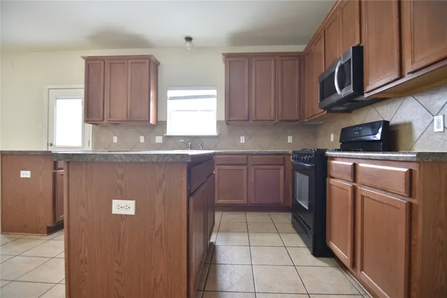 a kitchen with a sink a stove and cabinets