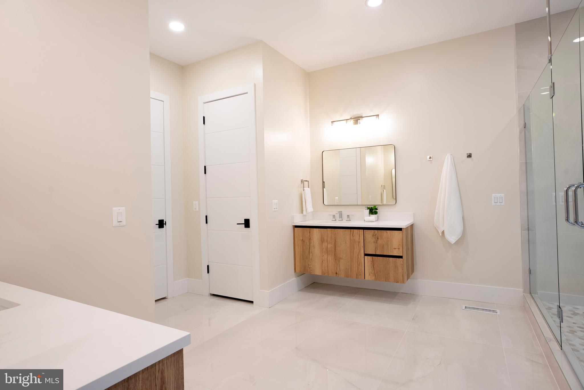 5947 Doyle Road Clifton, VA 20124 - Photo 36 of 69 a spacious bathroom with a double vanity sink a mirror and a bathtub