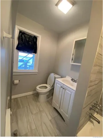 a bathroom with a toilet a sink and mirror