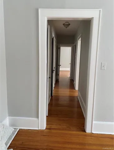 a view of a hallway with wooden floor