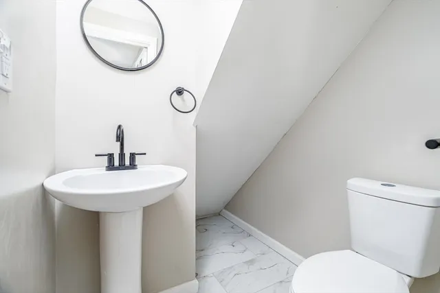 a bathroom with a toilet sink and mirror