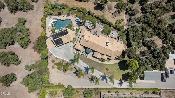 an aerial view of a house with a yard and pool