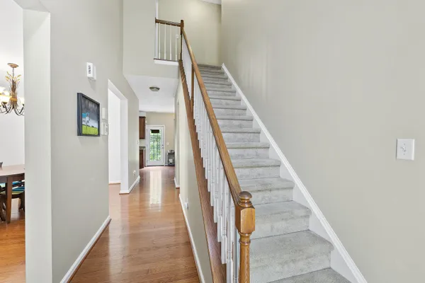 a view of a hallway with wooden floor and staircase