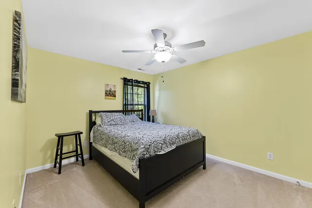 a bed sitting in a spacious bedroom next to a window