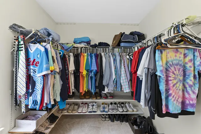 a view of walk in closet with clothes