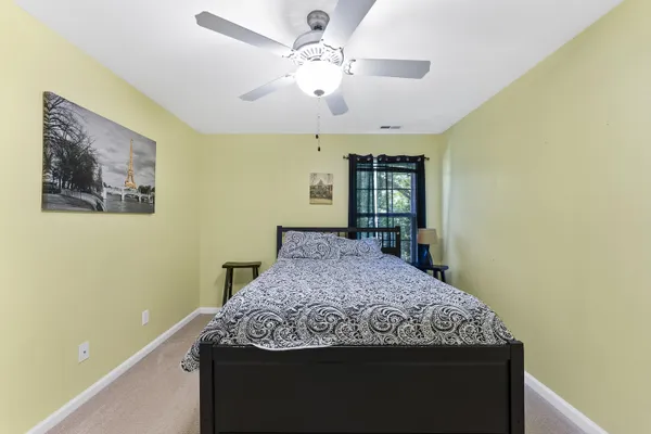 a bedroom with a large bed and a chandelier
