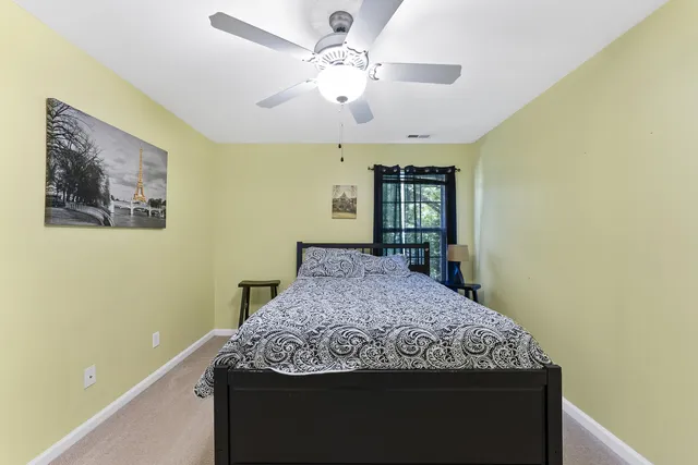 a bedroom with a large bed and a chandelier