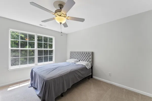 a bedroom with a bed and a large window