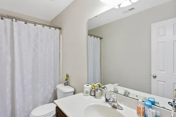 a bathroom with a sink vanity mirror and toilet