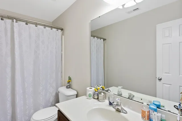 a bathroom with a sink vanity mirror and toilet