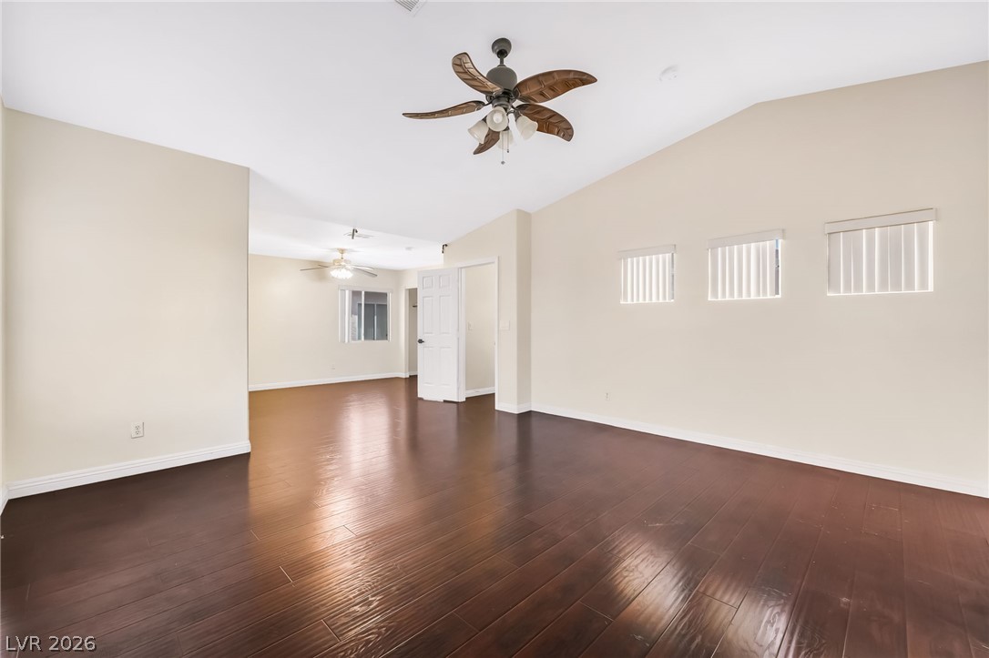 5905 Crumbling Ridge Street Henderson, NV 89011 - Photo 16 of 28 Rich wood floors sweep through this versatile living space featuring vaulted ceilings and high windows.