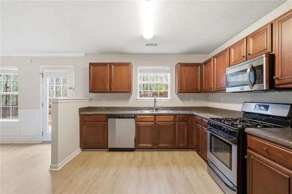 a kitchen with stainless steel appliances granite countertop a stove top oven a sink dishwasher and a microwave oven on the blue kitchen countertops