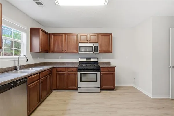 a kitchen with stainless steel appliances granite countertop a stove and a sink
