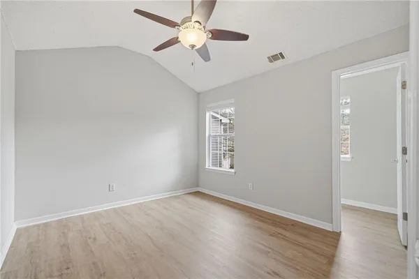 an empty room with a window and a fan