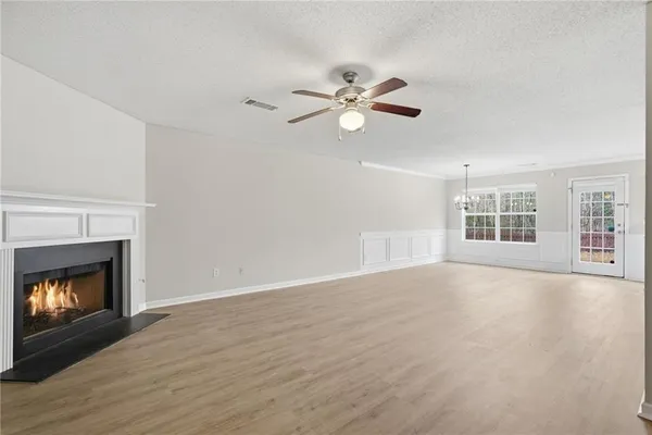 a view of an empty room with window and fireplace