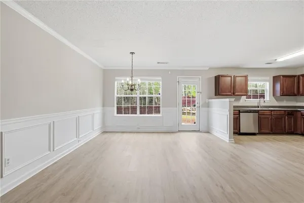 a view of a kitchen with a sink wooden cabinets and stainless steel appliances