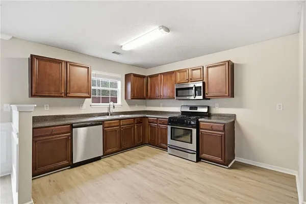 a kitchen with stainless steel appliances granite countertop a stove top oven a sink and dishwasher