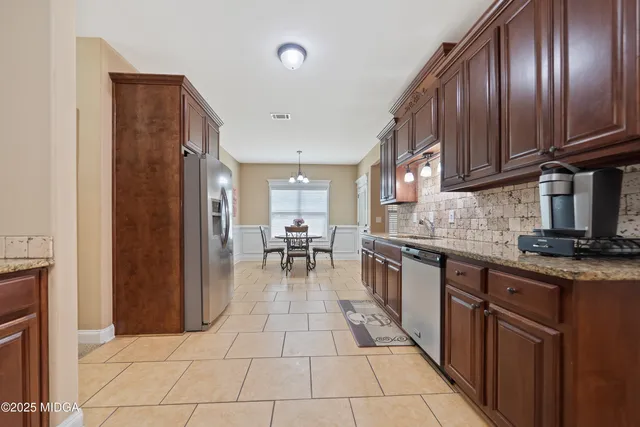 a kitchen with stainless steel appliances granite countertop a refrigerator and a sink