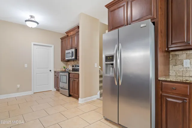 a kitchen with stainless steel appliances granite countertop a refrigerator and a sink