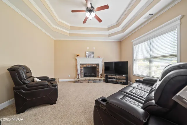 a living room with furniture a fireplace and a large window