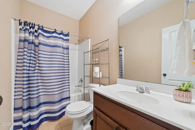a bathroom with a sink a toilet and shower curtain