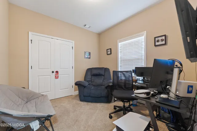 a view of a workspace with furniture and a window