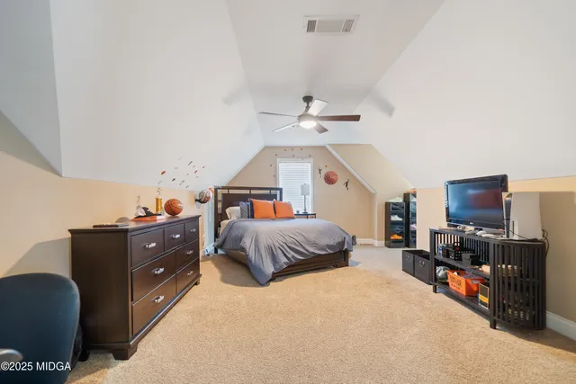 a bedroom with a bed and flat screen tv